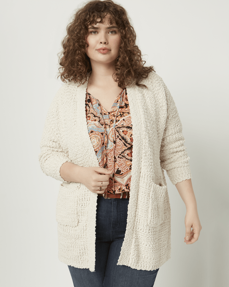 Front of a model wearing a size 1X Nancy Popcorn Knit Pocket Cardigan in Ivory by East Adeline. | dia_product_style_image_id:210713